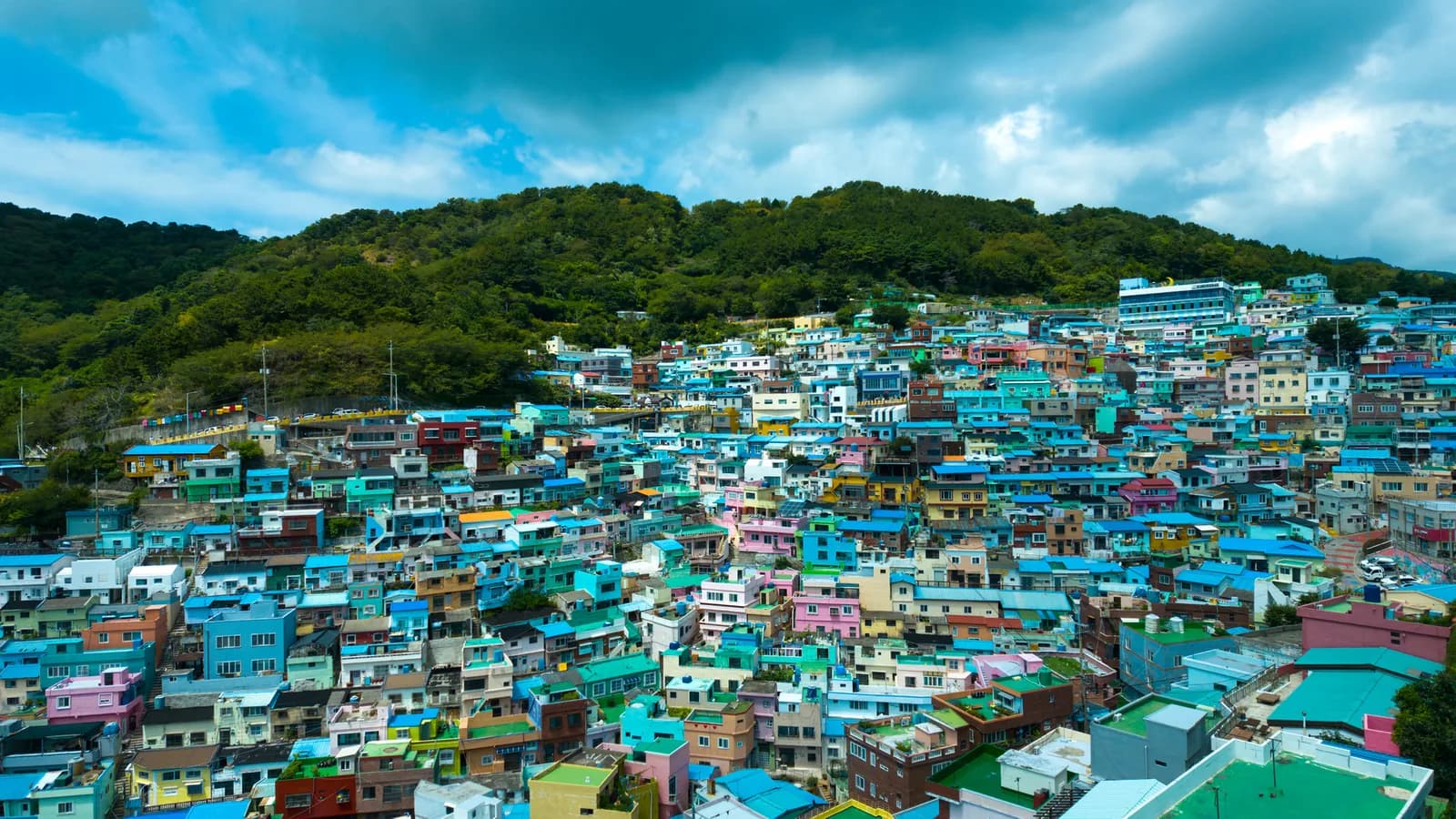 Le case colorate di Gamcheon si affollano sul pendio sotto una collina verde