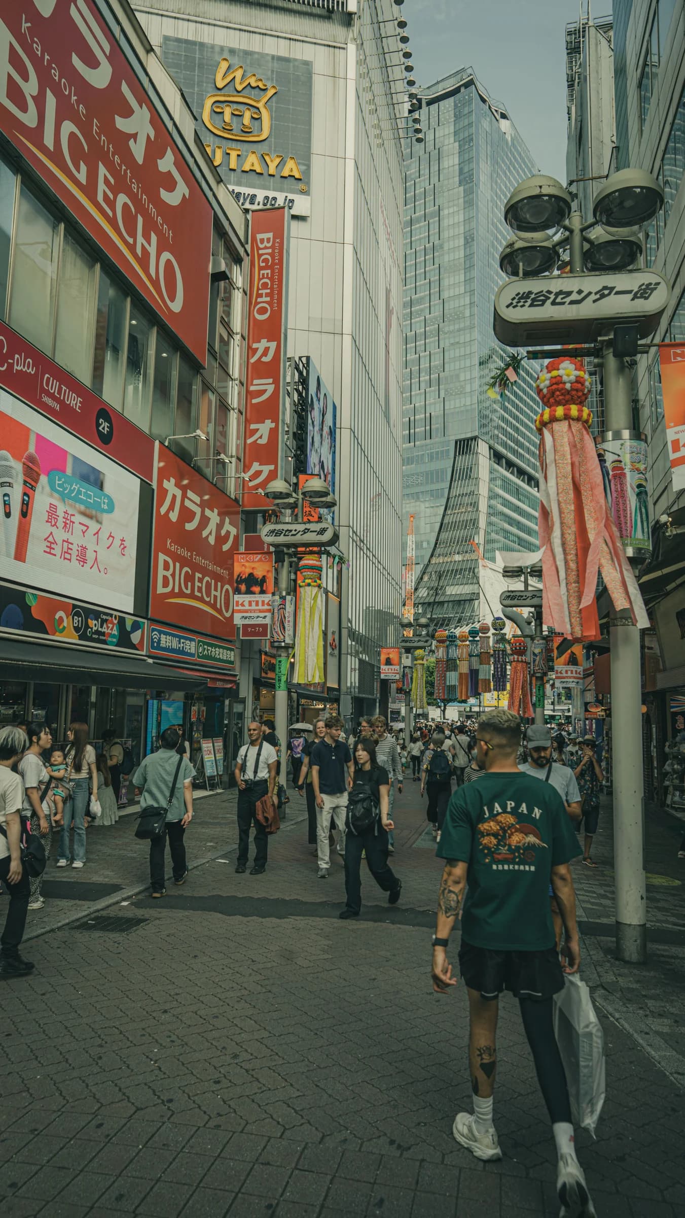 A busy Shibuya street filled with signs and hanging decorations